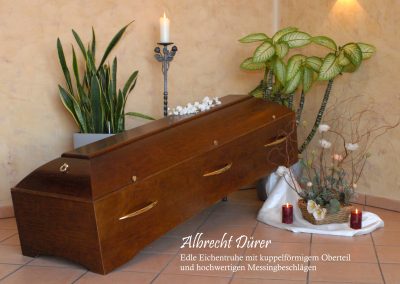 Ein mit Pflanzen, Kerzen und dekorativen wei&szlig;en Blumen geschm&uuml;ckter Holzsarg ruht anmutig auf einem gefliesten Boden und verk&ouml;rpert einen eleganten Rahmen f&uuml;r eine herzliche Bestattung.