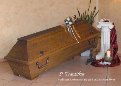 Ein wundersch&ouml;ner Holzsarg mit dekorativen Griffen steht mit Blumen geschm&uuml;ckt und auf einem St&auml;nder in der N&auml;he brennt eine leuchtende Kerze. Alles ist sorgf&auml;ltig f&uuml;r eine respektvolle Bestattung arrangiert, und ein deutscher Text rundet die heitere Atmosph&auml;re ab.