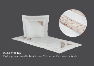 Elfenbeinfarbenes Bettw&auml;scheset mit Kupferakzenten und gestepptem Design, bestehend aus Kissen und Decke auf grauem Hintergrund, erinnert an die Ruhe und Eleganz feierlicher Momente wie Bestattungszeremonien.