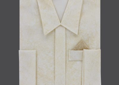 Ein gefaltetes, hellcremefarbenes Papier, das einem Hemd mit Einstecktuch &auml;hnelt, liegt feierlich auf einem dunklen Hintergrund und weckt Gedanken an W&uuml;rde und die zeitlosen Traditionen der Bestattung.