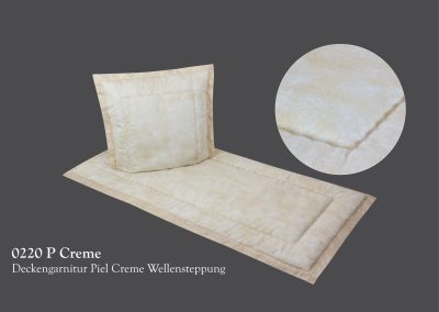 Das cremefarbene Steppbettw&auml;scheset strahlt heitere Schlichtheit aus und ruht auf grauem Untergrund. Die kreisf&ouml;rmige Nahstruktur weckt Gef&uuml;hle einer sanften Bestattung.