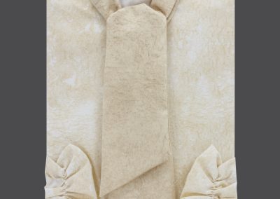 Cremefarbene Damenbluse mit Schalkragen und gerafften Manschetten auf dunklem Grund, die an heitere Eleganz erinnert. Text: &bdquo;2014 P Creme&ldquo; auf Deutsch, was eine zeitlose Anmut evoziert, die an Bestattungstraditionen erinnert.
